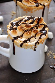 two mugs filled with hot chocolate and marshmallows on top of each other