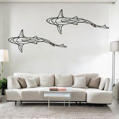 a living room with two couches and a wall decal that has dolphins on it