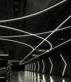 two cars are parked in an underground parking garage with bright lights on the ceiling and floor