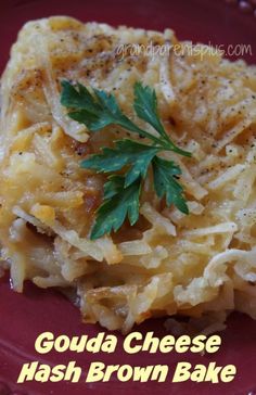 a red plate topped with hash browns covered in grated cheese and garnished with parsley