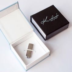 an open box with a lighter in it sitting next to a white and black box