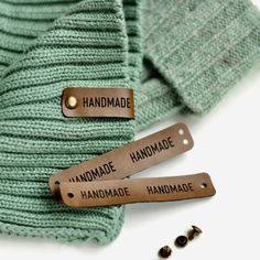 two leather tags that say handmade on them