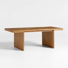 a wooden table sitting on top of a white floor next to a wall with no one around it