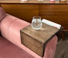 a pink couch with a glass on top of it