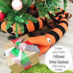 an orange and black snake stuffed animal next to presents under a christmas tree with text overlay