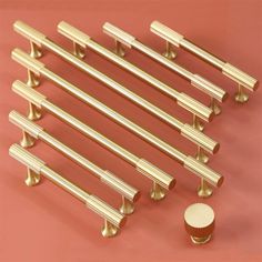 a set of six brass door handles and knobs with cupcake top on a pink background