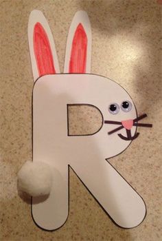 the letter r is for rabbit with ears on it's head and eyes painted white