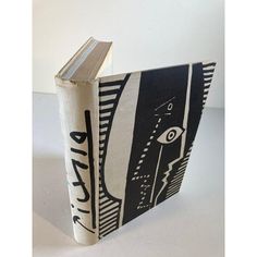 an open book with black and white designs on it's cover, sitting on a table