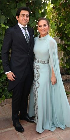 a man and woman dressed in formal wear posing for the camera