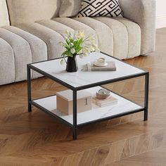 a white coffee table sitting on top of a hard wood floor next to a couch