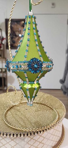 a green lamp hanging from a ceiling in a living room with gold and blue accents