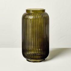 a green vase sitting on top of a white table