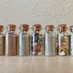 five glass jars filled with different types of rocks