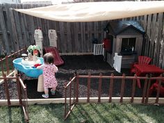 two children playing in a play yard with toys