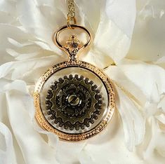 ✨️FREE SHIPPING (USPS Ground Advantage Mail ONLY) and will ship out in ONE BUSINESS Day ✨️ Golden Epoch Steampunk Necklace Think back in time while leaping forward in style with this Golden Epoch Steampunk Necklace. Expertly crafted, the central antique-bronze steampunk wheel stands as a testament to the intricate machinery of yesteryears, while the sparkling golden frame whispers tales of opulence and luxury. Encased within a lustrous gold bezel reminiscent of vintage pocket watches, this neckl Pocket Watch Design, Gold Steampunk Pocket Watch With Locket, Antique Gold Steampunk Jewelry Gift, Gold Steampunk Metal Necklaces, Antique Gold Steampunk Brass Necklace, Gold Steampunk Necklace Vintage, 16 Inch Necklace, Golden Frame, Vintage Pocket Watch