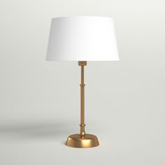 a gold lamp with a white shade on it