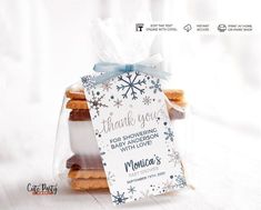 some cookies are in a clear bag with a blue ribbon around it and the tag says thank you for showing baby snowflakes