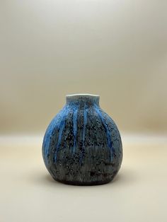 a blue vase sitting on top of a white table