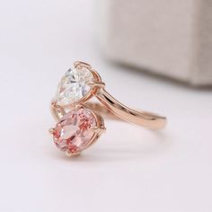 two heart shaped pink and white diamond rings on top of each other, one with a rose cut diamond in the middle