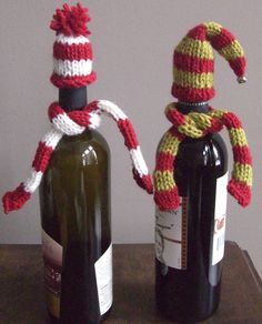 two wine bottles with knitted hats on them