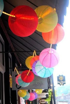 colorful paper lanterns hanging from the side of a building