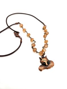 This clever little fox is all curled up with a bushy tail to keep him warm. He hangs from a necklace made of hand wrapped  Czech Glass beads that compliment his copper color. The beads are attached to a brown leather cord with a lobster claw clasp. The pendant measures 1" wide by 1" tall, on a 21"  necklace. Thank you for visiting Rock n Rose Jewelry!  I appreciate your business! Rose Jewelry, Hand Wrap, Copper Color, Handmade Necklace, Animal Lovers, Czech Glass Beads, Leather Cord, Czech Glass, Lobster Claw