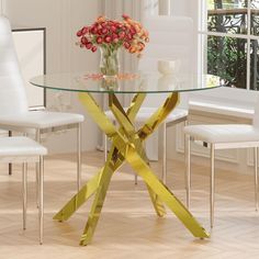 a glass dining table with yellow tape wrapped around the base and flowers in a vase on top