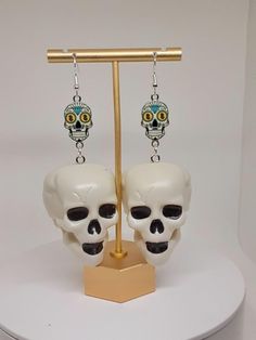 These awesome earrings are made with plastic skulls and silver tone materials. Halloween Skull Print Earrings, Halloween Skull Print Skull Earrings, White Skull Jewelry For Day Of The Dead, Halloween Skull Jewelry In White, White Skull Jewelry For Halloween, White Skull-shaped Halloween Jewelry, Halloween White Skull Jewelry, Handmade Skull Earrings For Day Of The Dead, White Skull Print Jewelry