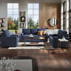 a living room filled with blue couches next to large windows and wooden flooring