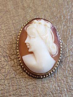 This is a vintage AMCO cameo brooch/pendant. It is oval and is stamped 1/20 14 K GF. The cameo measures just over .75 x a bit over 1 inch. Don't forget to stop in at my other Etsy shop... http://www.etsy.com/shop/xtdesigns. Follow me on Twitter at... MyYiayiaHadThat@MyYiayiaHadThat. If you have a wish list or are looking for something specific, please ask. I may have exactly what you are looking for. As always please convo me with any questions or concerns regarding this item or with any interna Formal Cameo Brooch, Luxury Classic Cameo Brooches, Collectible Oval Cameo Brooches, Formal Cameo Pendant Brooch, Collectible Cameo Pendant Brooches, Cameo Brooch, Purple Velvet, Gold Filled, Give It To Me