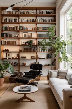 a living room filled with furniture and bookshelves next to a window covered in plants