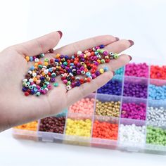 a person holding out their hand full of beads