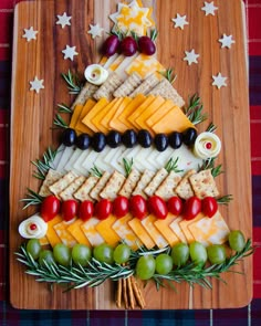 a christmas tree made out of cheese, crackers and olives on a cutting board