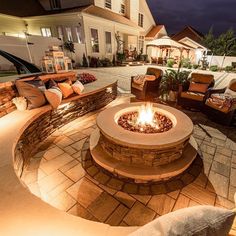 an outdoor fire pit surrounded by seating and lights