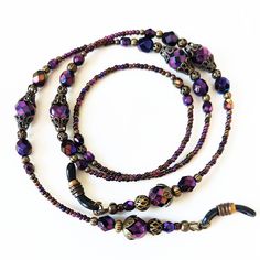 "Iridescent Purple Beaded Eyeglass Chain. Variety of faceted Czech glass beads with an AB finish, this gives the beads a rainbow effect. The lanyard is accented with antiqued brass filigree bead caps create a vintage look. I completed the lanyard with Czech glass seed beads with eyeglass connectors. Show off your unique sense of style when you wear this wonderful eyeglass chain. FEATURES > Total length 26\", may be adjusted upon request > Your choice of eyeglass connectors, skinny arm or wide arm. > To ensure long lasting wear I use professional quality beading wire (49 strand). The beading wire is very strong and flexible, providing a soft drape and it lays softly on the neck for maximum. Wire guardians are incorporated to protect wire from wear. The wire is double crimped for a secure ho Iridescent Adjustable Round Bead Necklaces, Iridescent Adjustable Necklace With Round Beads, Adjustable Glass Beaded Necklaces For Party, Adjustable Glass Beaded Chain Jewelry, Adjustable Iridescent Necklace For Festivals, Adjustable Glass Jewelry With Faceted Beads, Adjustable Glass Faceted Beads Jewelry, Iridescent Adjustable Necklace For Festivals, Glass Necklaces With Faceted Beads For Festivals