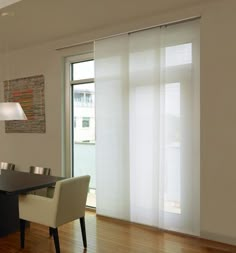 a dining room table and chairs with sliding glass doors