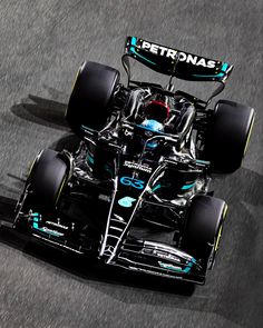 the mercedes formula car is driving down the track