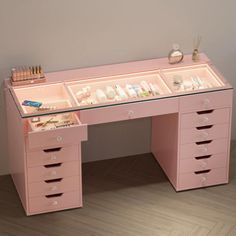 a pink desk with drawers and lights on it