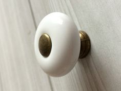 a close up of a white door handle with gold accents