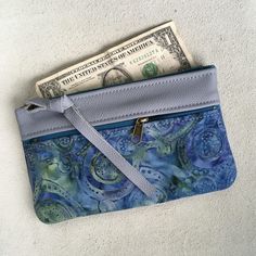 "Wallet, Clutch,or Phone case in Sky Blue Italian Leather paired with a pretty Boho Paisley Batik.This bag can carry your essentials and be your only bag-or use it in your big purse as I do for a wallet. Front zip works for change and top zip opens main section which fits dollar bills. There's also a small inside pocket that holds credit cards. Nice to carry jewelry when traveling. Or for your 7\" Knitting Needles and Crochet Hooks. 7 1/2\" wide 4 3/4\"deep PLEASE NOTE BATIK VARIES SLIGHTLY Matc Blue Clutch With Zipper Pouch For Daily Use, Blue Clutch With Card Slots For Gift, Blue Clutch Wallet For Everyday Use, Blue Clutch With Card Slots As Gift, Blue Wallet With Removable Pouch As Gift, Blue Zipper Pouch Clutch For Daily Use, Blue Wallets With Removable Pouch As Gift, Handmade Blue Wallet For Everyday Use, Blue Clutch Coin Purse For Daily Use