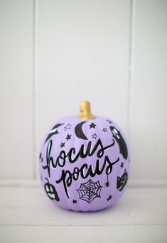 a purple painted pumpkin with the words hoccuss pocuss written on it