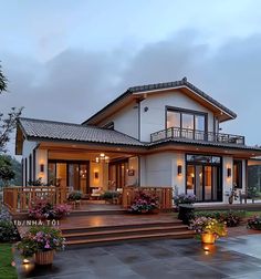 a house that is lit up at night with lights on the porch and steps leading to it