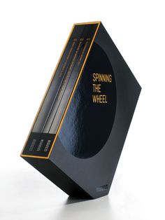 a black and yellow box with the words spinning the wheel on it's side