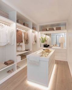 a white closet filled with lots of clothes