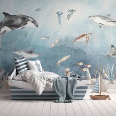 an ocean themed bedroom with dolphins and other marine creatures painted on the wall behind it