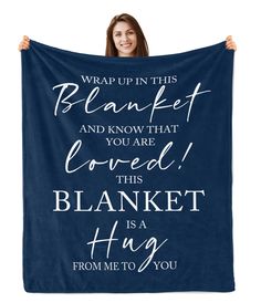 a woman holding up a blanket that says, wrap up this blanket and know that loved this blanket is a hug from me to you