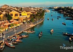 boats are floating on the water in front of some buildings and people walking down it