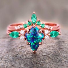 Indulge in the timeless elegance of our Skye Blue Fire Opal & Emerald Ring Set, crafted exclusively for women seeking sophistication and allure. Delicately encased in luxurious 14K rose gold vermeil, this engagement ring radiates with ethereal beauty.►The centerpiece features a captivating Skye Blue Fire Opal, renowned for its mesmerizing play of colors reminiscent of the sky at dawn. Enhanced by the vibrant allure of emeralds, each gemstone exudes a natural brilliance, symbolizing growth, renew Fire Opal Rings, Elegant Rose Gold Emerald Ring In 14k, Classic Rose Gold Emerald Jewelry, Formal Rose Gold Emerald Ring, Elegant 14k Rose Gold Emerald Ring, Formal Rose Gold Emerald Ring With Accent Stones, Formal Multi-stone Rose Gold Jewelry, Formal Rose Gold Multi-stone Jewelry, Elegant Blue Multi-stone Emerald Ring