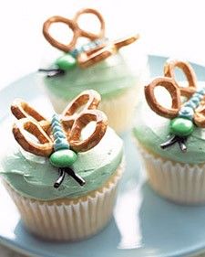 three cupcakes with frosting and pretzels in the shape of numbers