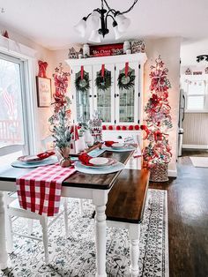 the dining room table is set for christmas with red and white decorations on it's walls